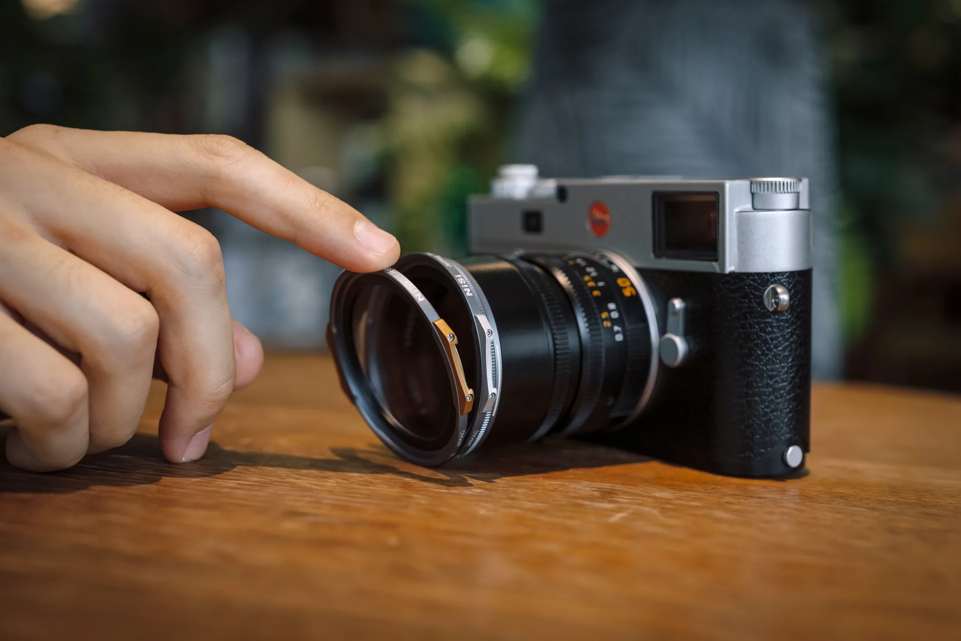 A 49MAG filter being snapped onto a Leica lens