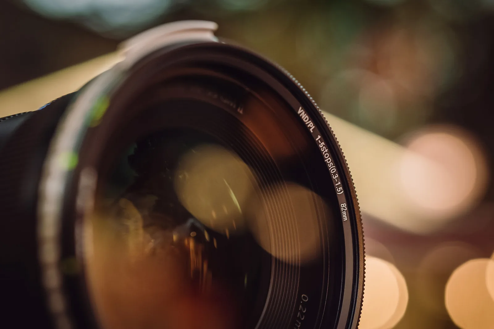 The front glass of a NiSi True Color VND/PL on a lens, with bokeh reflected in the coating