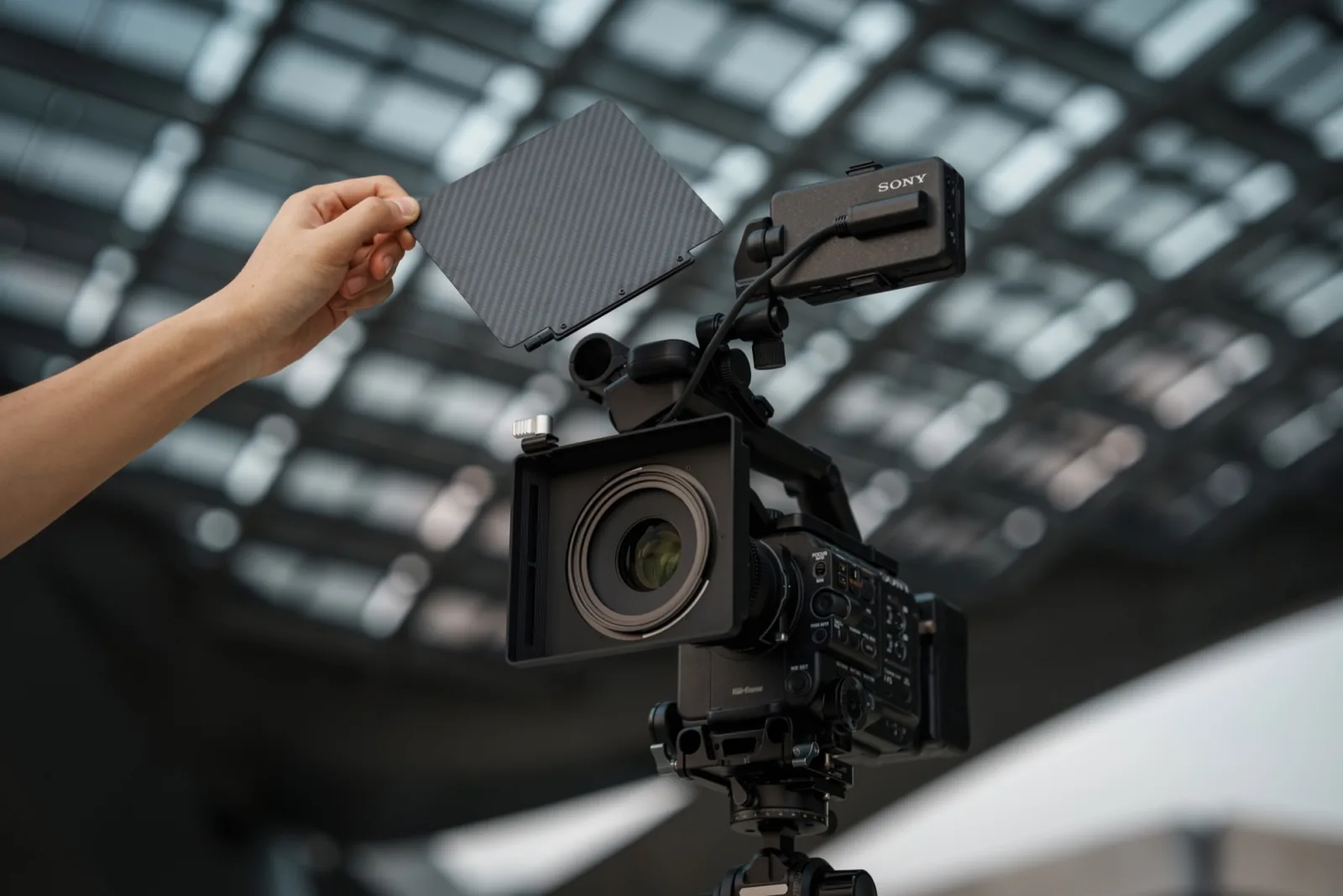 A hand lifting the carbon fibre top flag off the NiSi JetMag Pro Matte Box