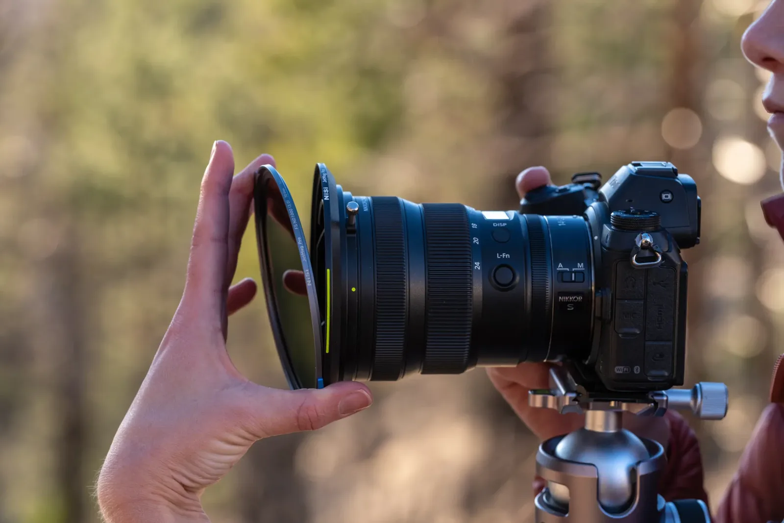 A MAXMAG filter being placed onto a lens adapter by hand